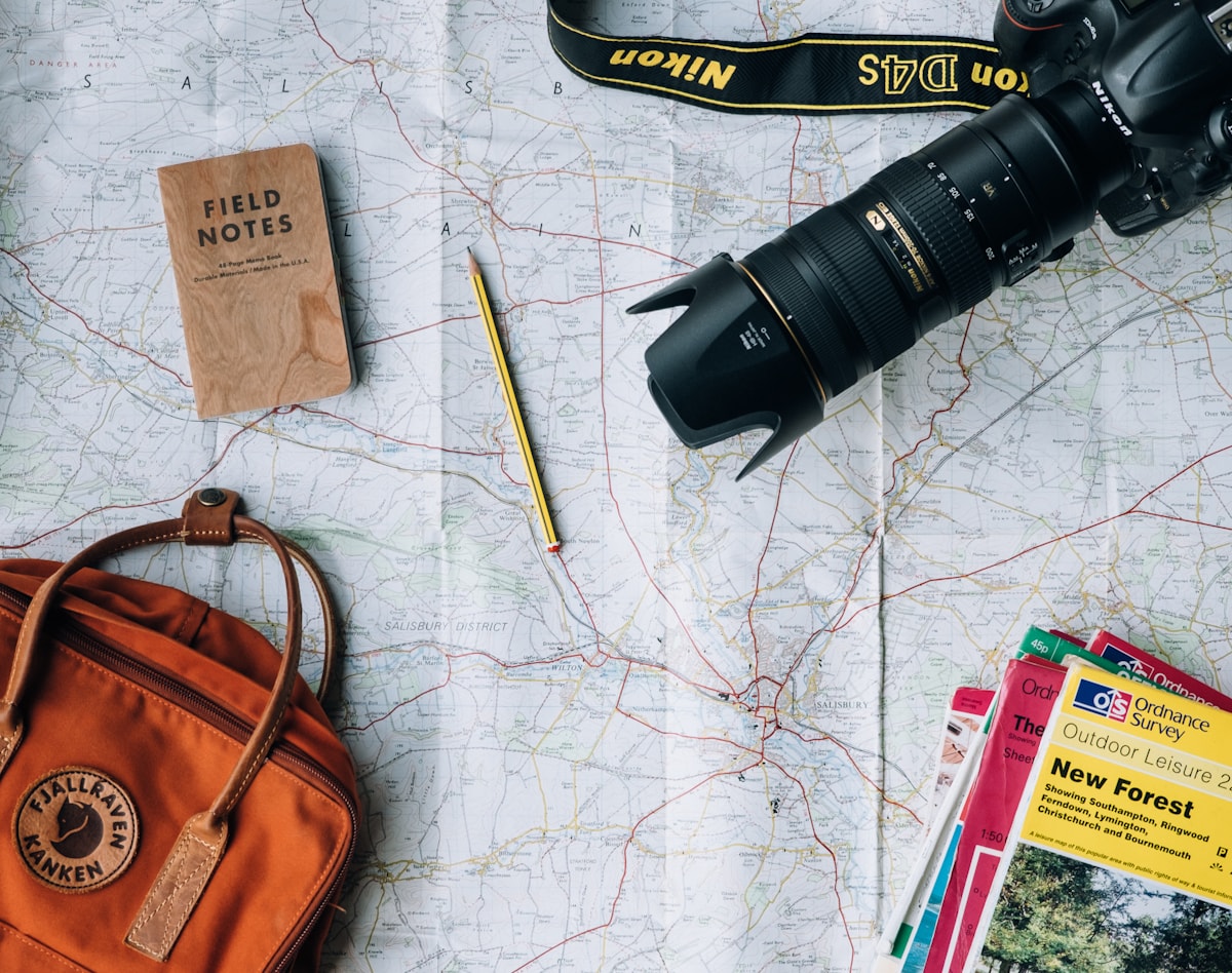 Travel planning notes, camera, and map arranged on a table