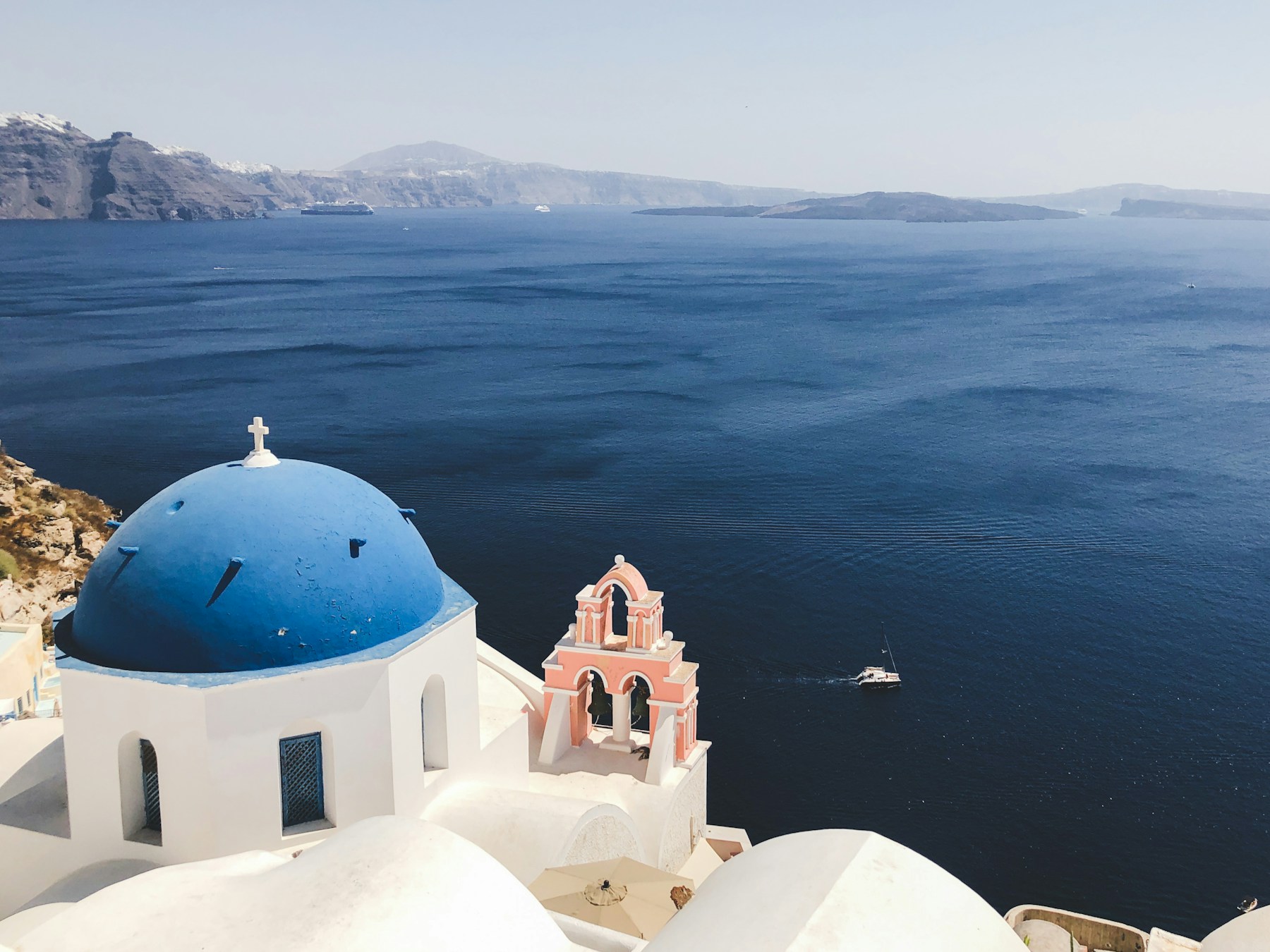A blue-domed church overlooking the Aegean Sea in Santorini, Greece